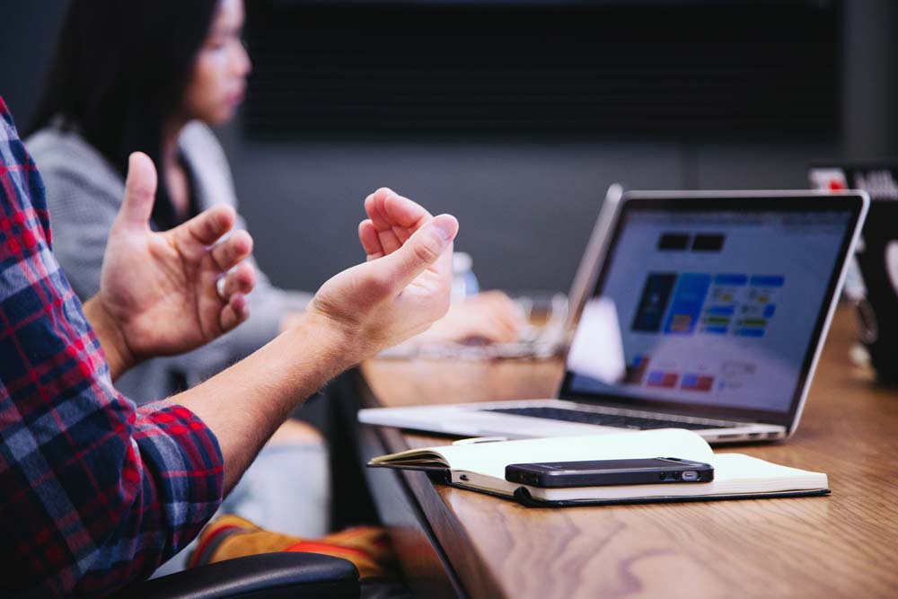 ecosystème : des personnes sont en réunions en train de traiter un sujet, autour d'une table, les ordinateurs ouverts. Un espace de coworking